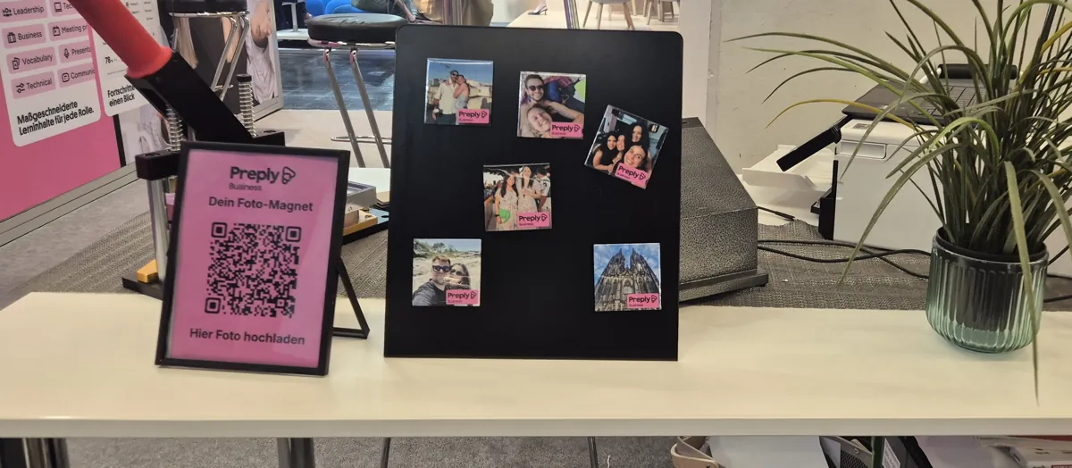 Magnetwand mit fertigen Fotomagneten im Preply-Branding und QR-Code zum Foto-Upload